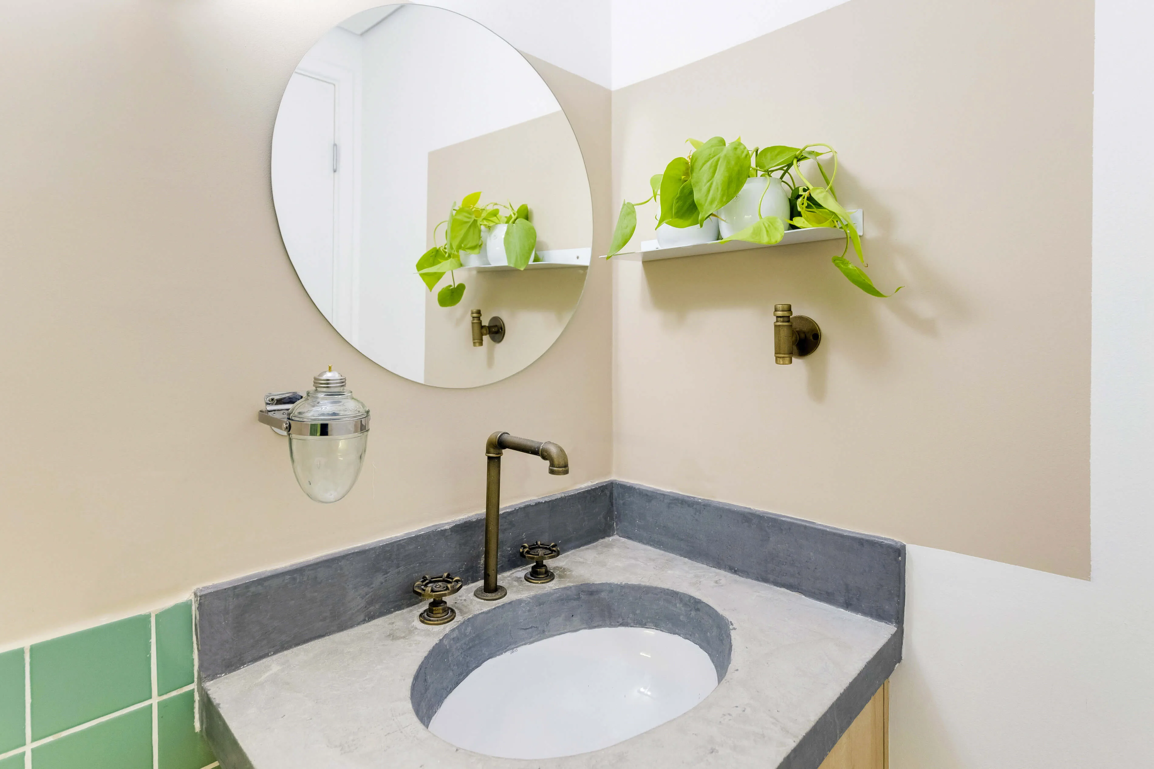 Detalhe da pia do banheiro com espelho grande e iluminação suave.