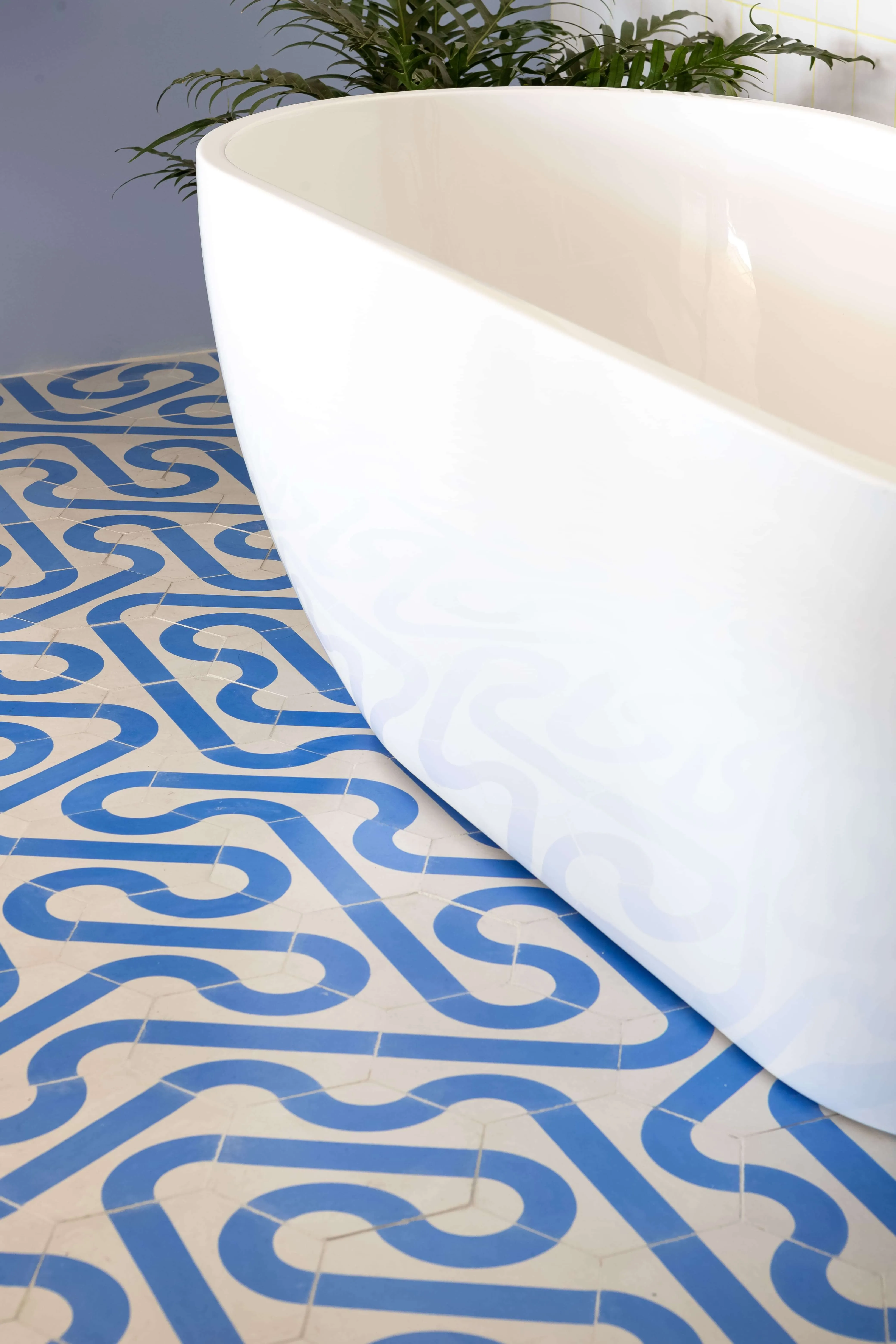 Detalhe do azulejo e banheira do banheiro integrado.