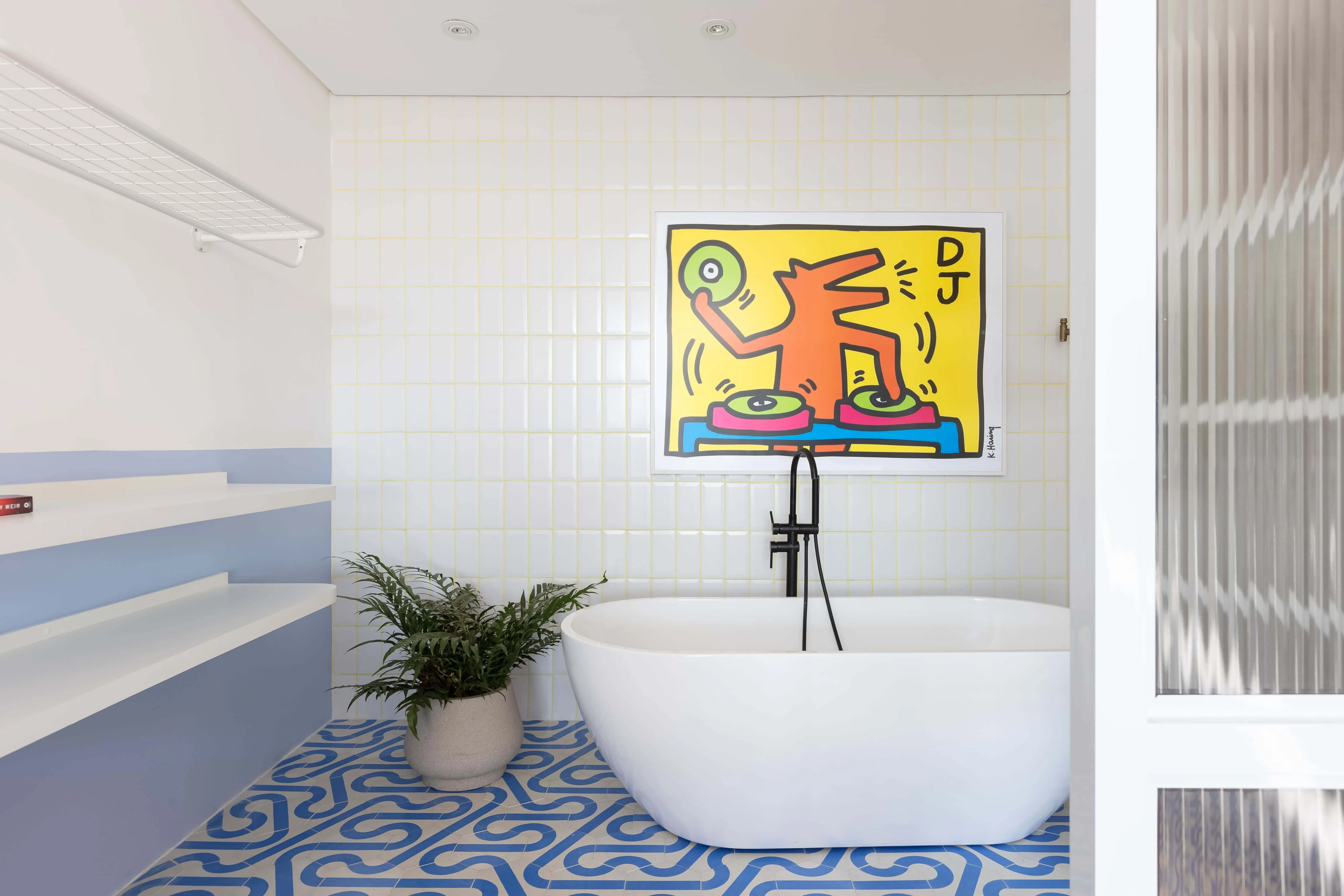 Área de banho com quadro colorido e detalhes vibrantes.