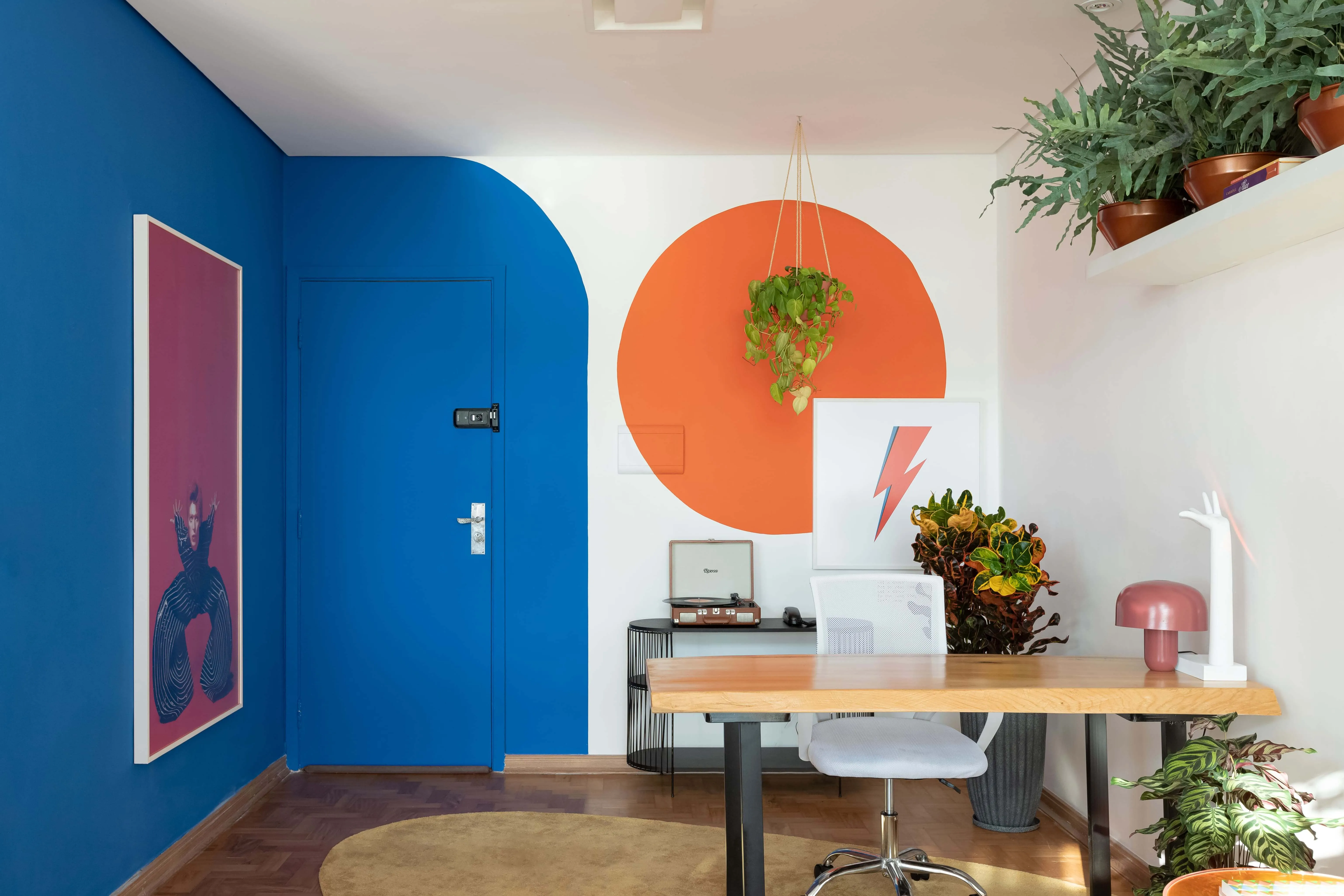Entrada do estúdio com mesa de escritório e elementos modernos.