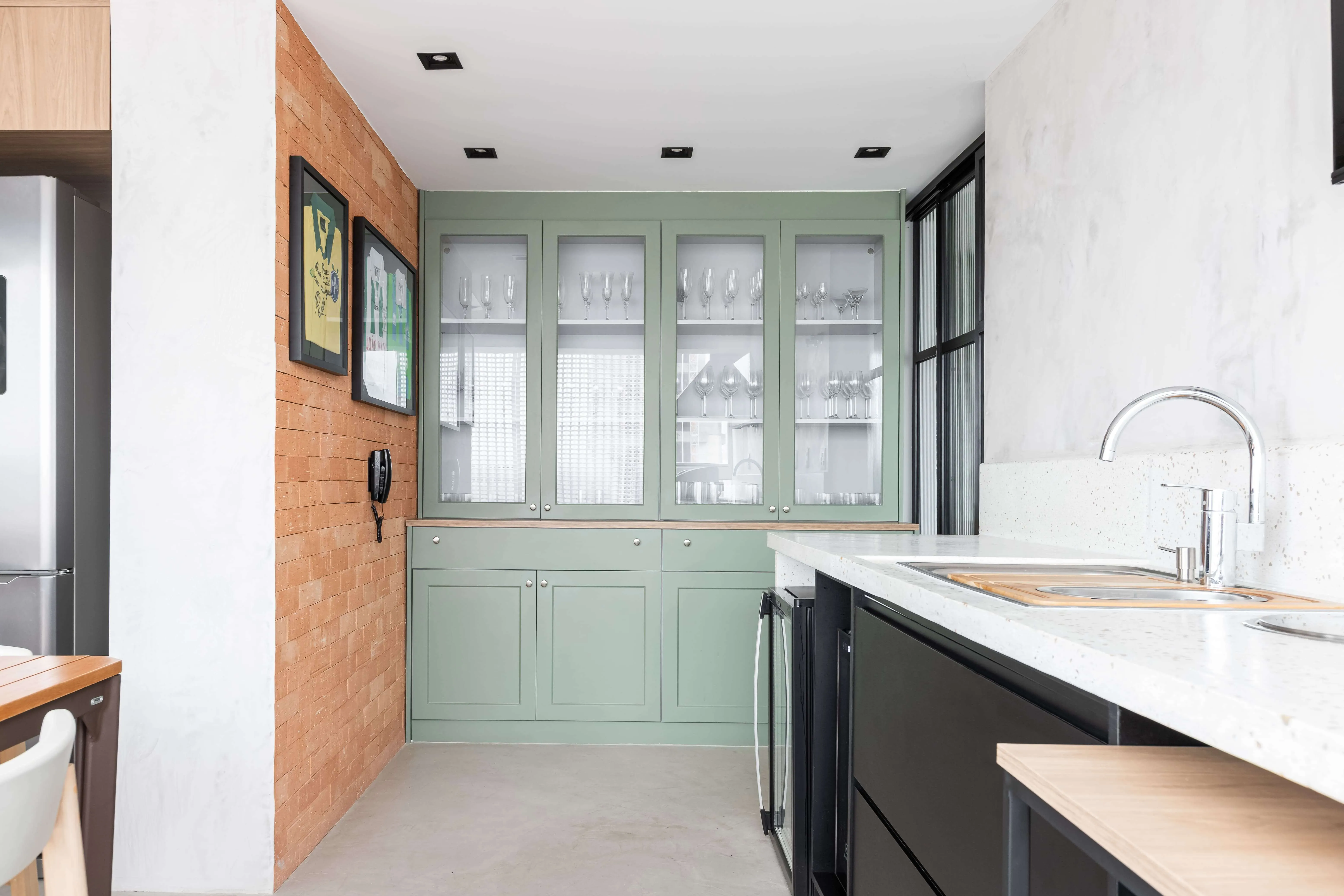 Cristaleira e textura de tijolos expostos na parede.