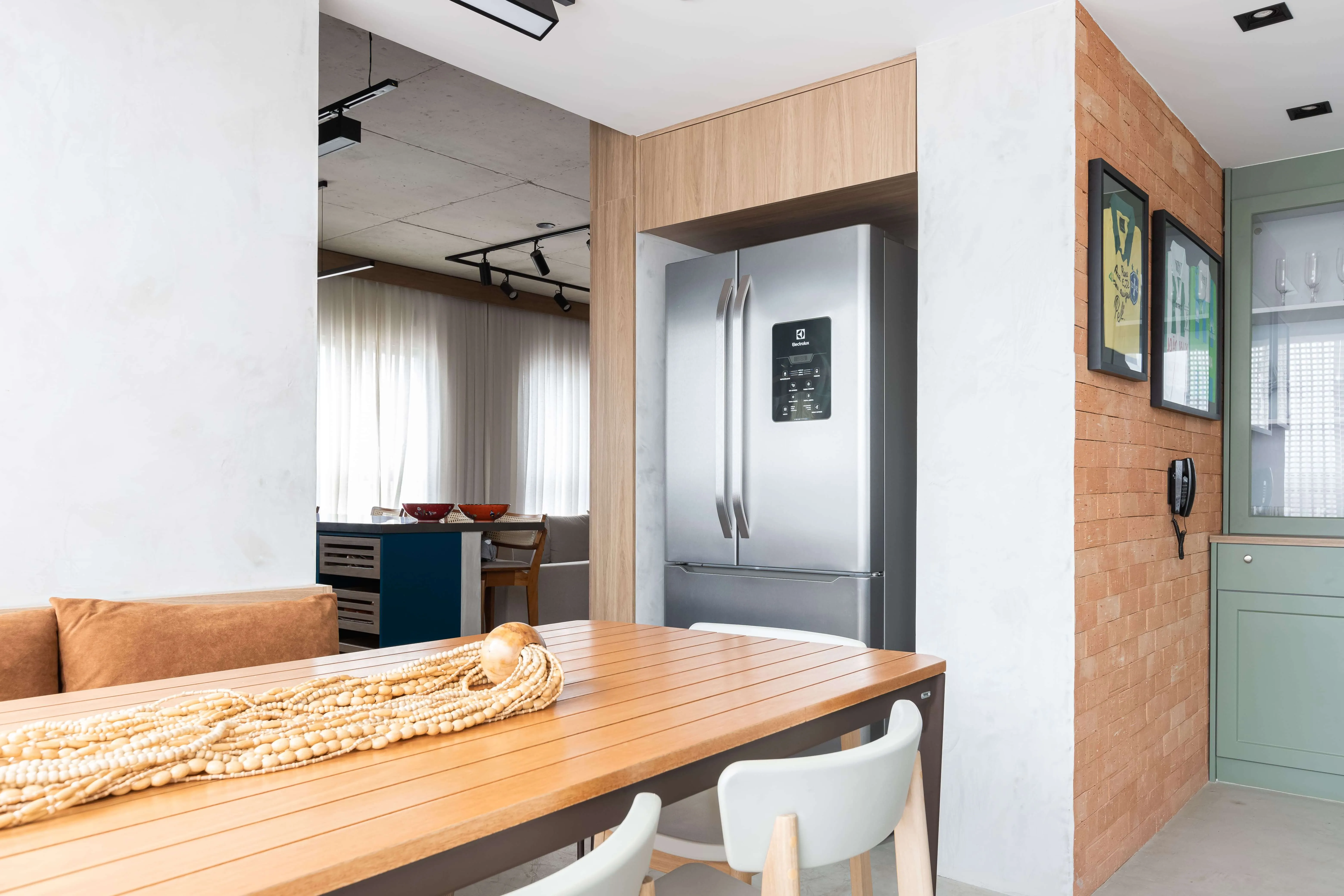 Mesa de jantar e geladeira em ambiente moderno.