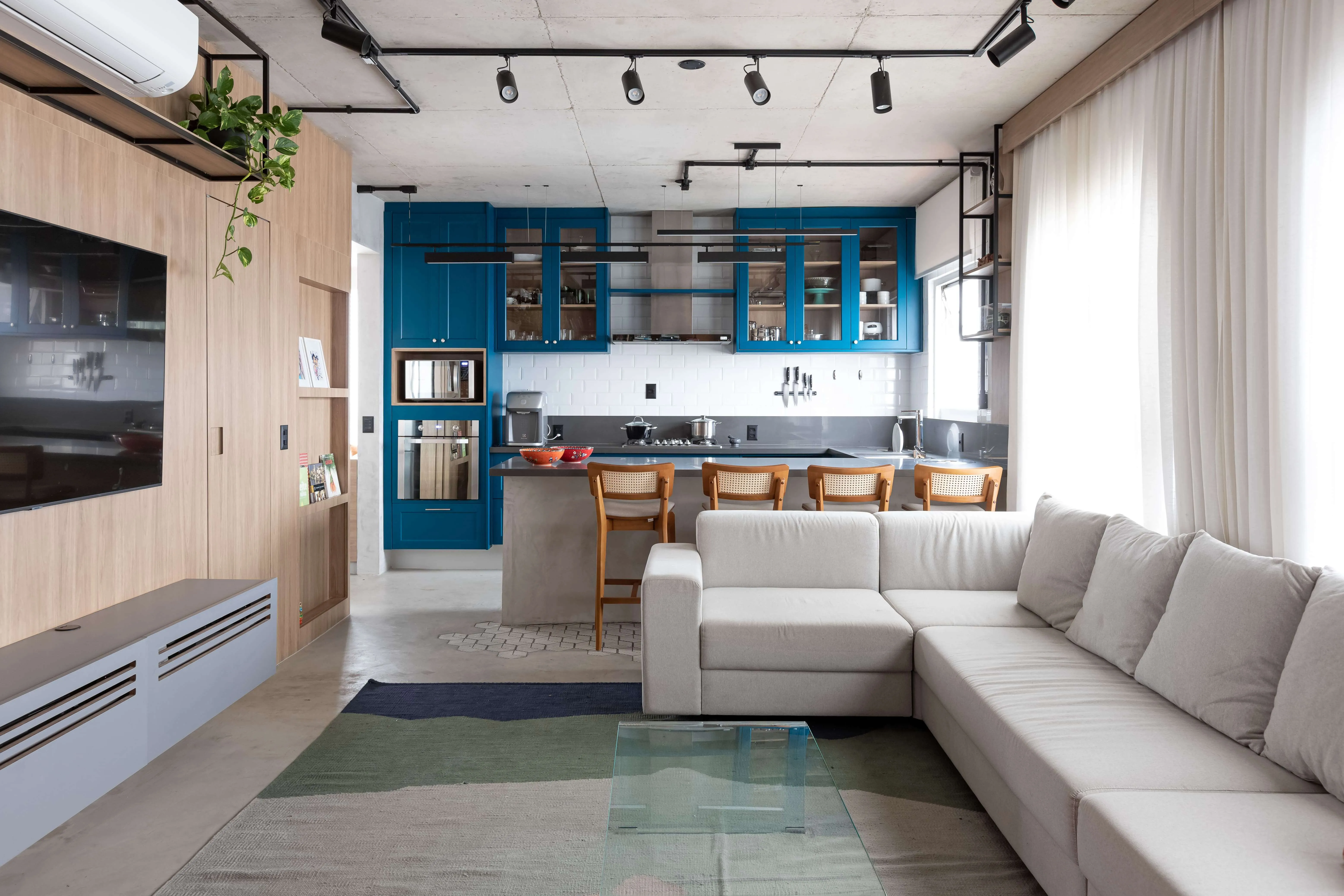 Ambiente integrado com cozinha, sala e jantar.