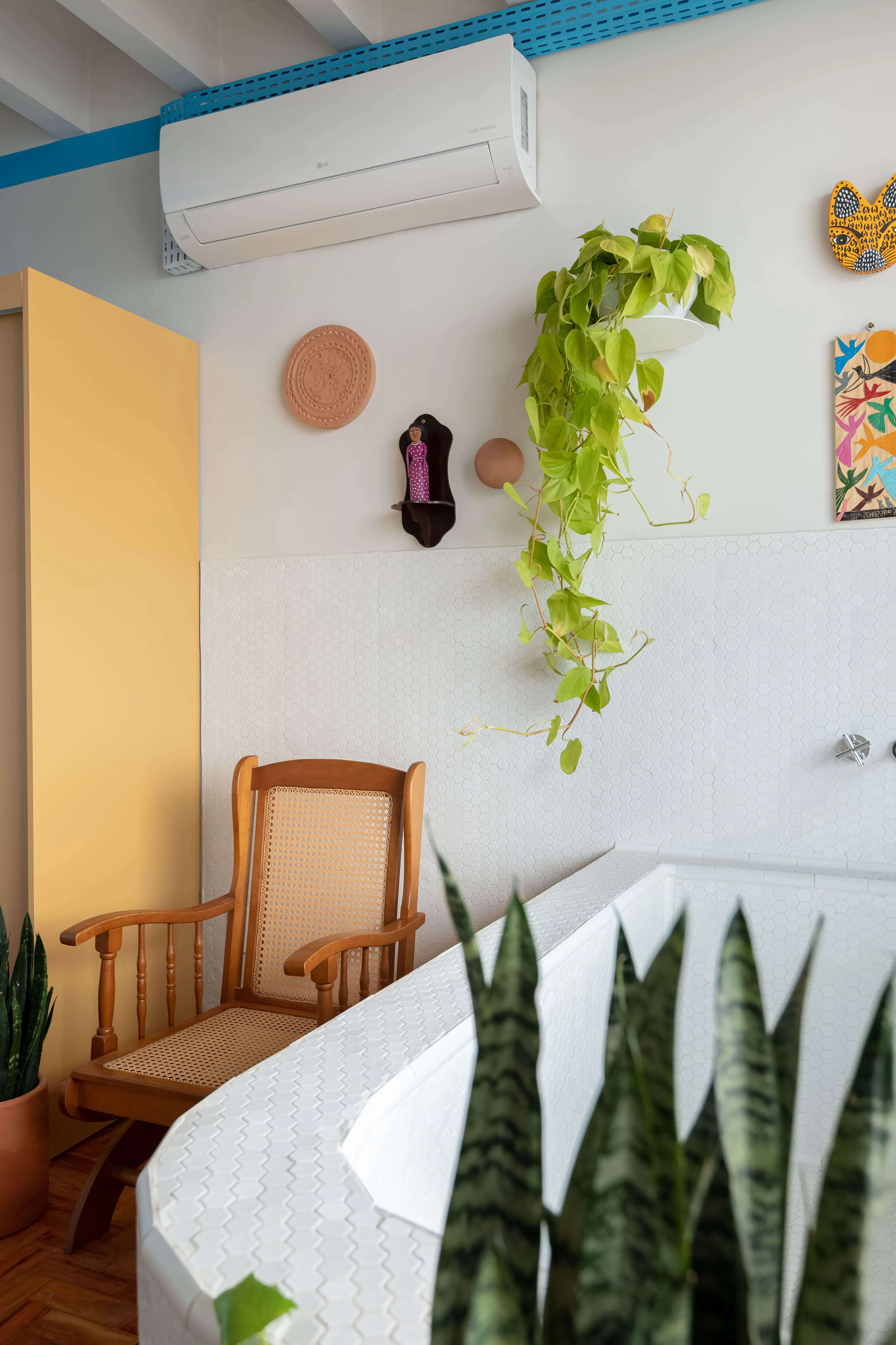 Quarto com cores quentes e obras de artistas locais.