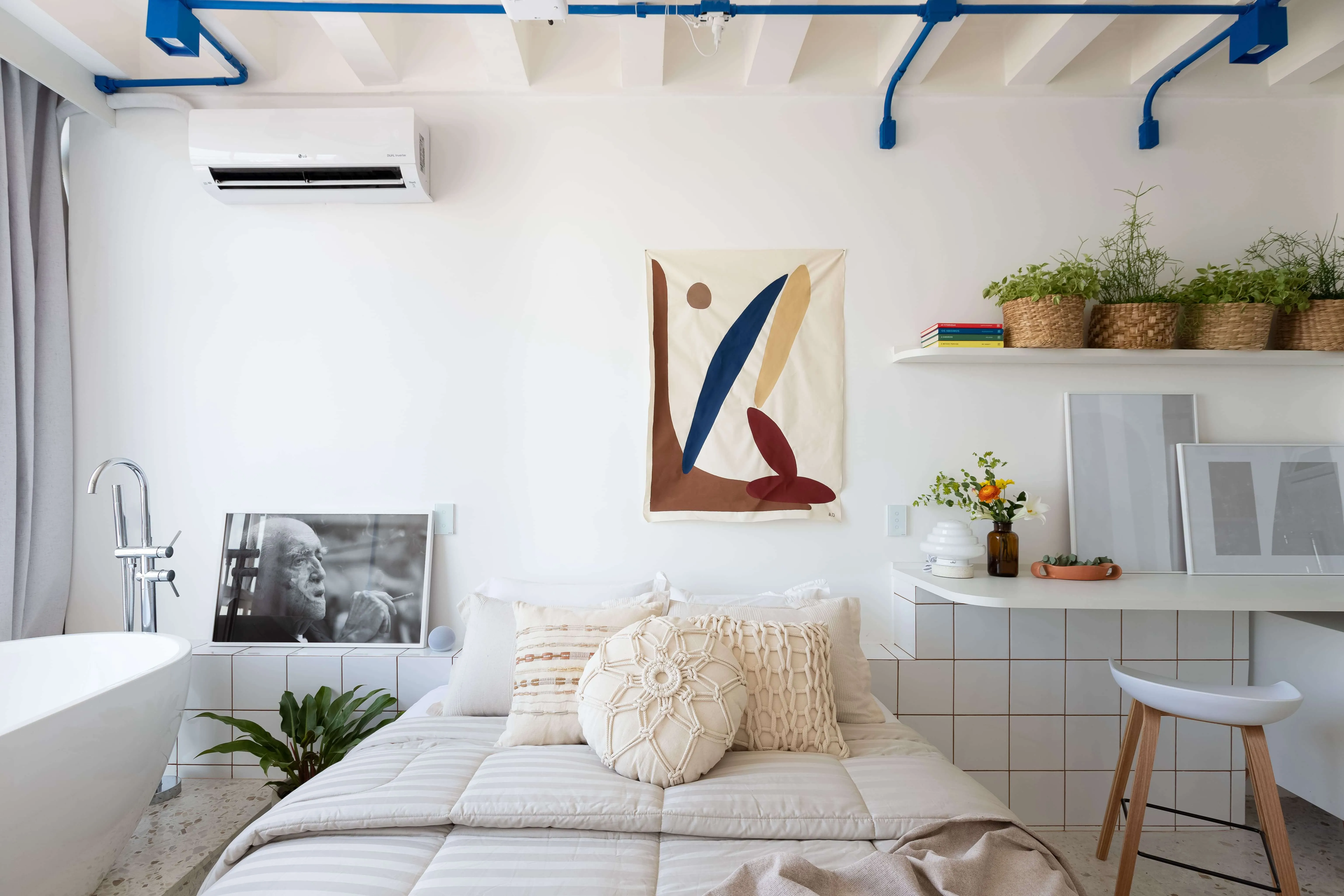 Área da cama com cabeceira azulejada e detalhes brancos.