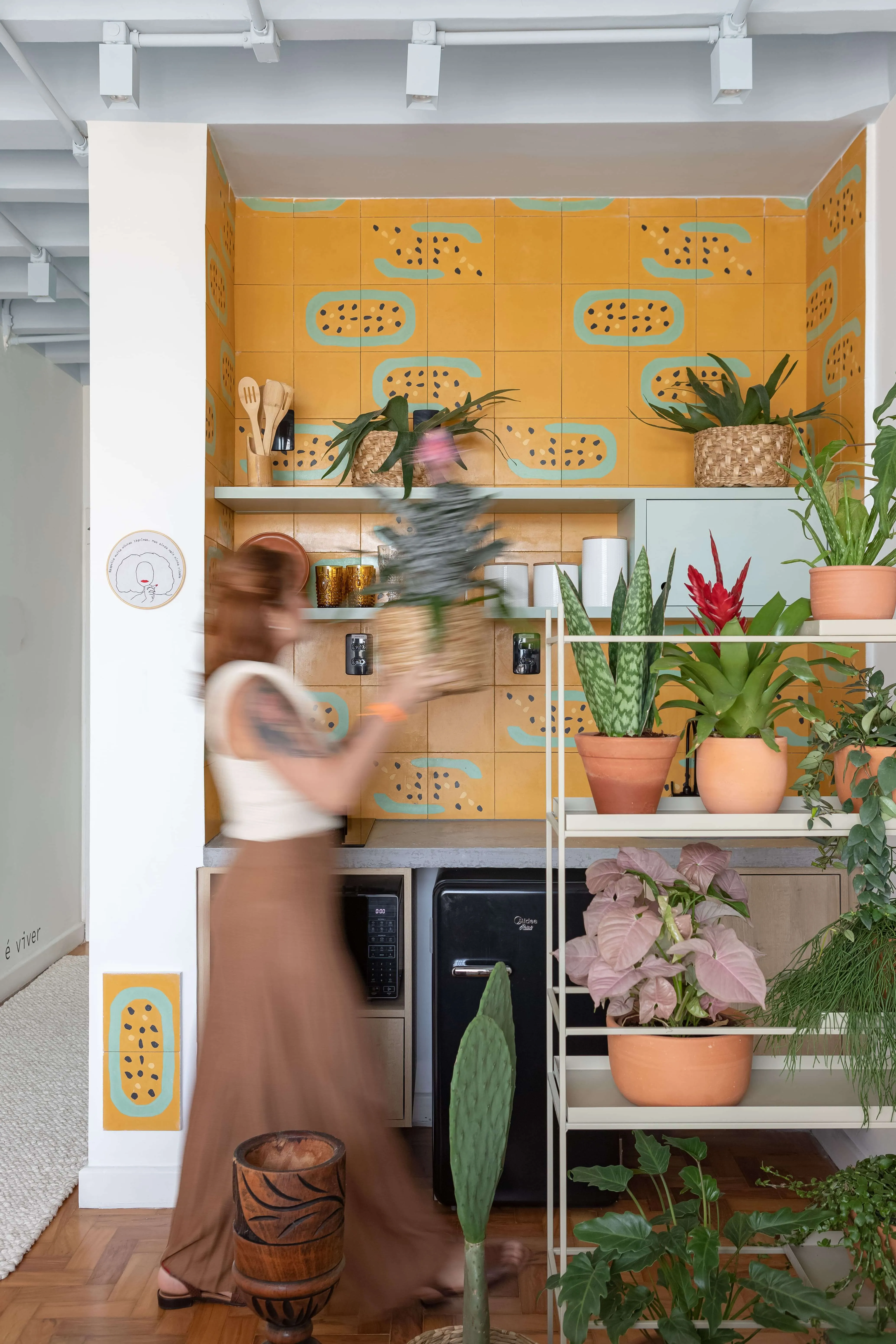 Azulejos exclusivos e plantas na área da cozinha.